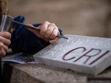 Francesco Bonello carves letters into a block of marble at the School of Arts and Crafts of the Fabbrica di San Pietro, Vatican, Friday. Feb. 14, 2025.