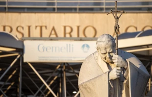 A statue of St. John Paul II is seen in front of the entrance to Rome’s Gemelli Hospital on Feb. 22, 2025, where Pope Francis continues to receive treatment for respiratory issues. Credit: Daniel Ibáñez/CNA