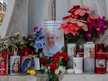 A makeshift shrine with devotional candles, flowers, and images of Pope Francis appears outside Rome’s Gemelli Hospital on Feb. 22, 2025.