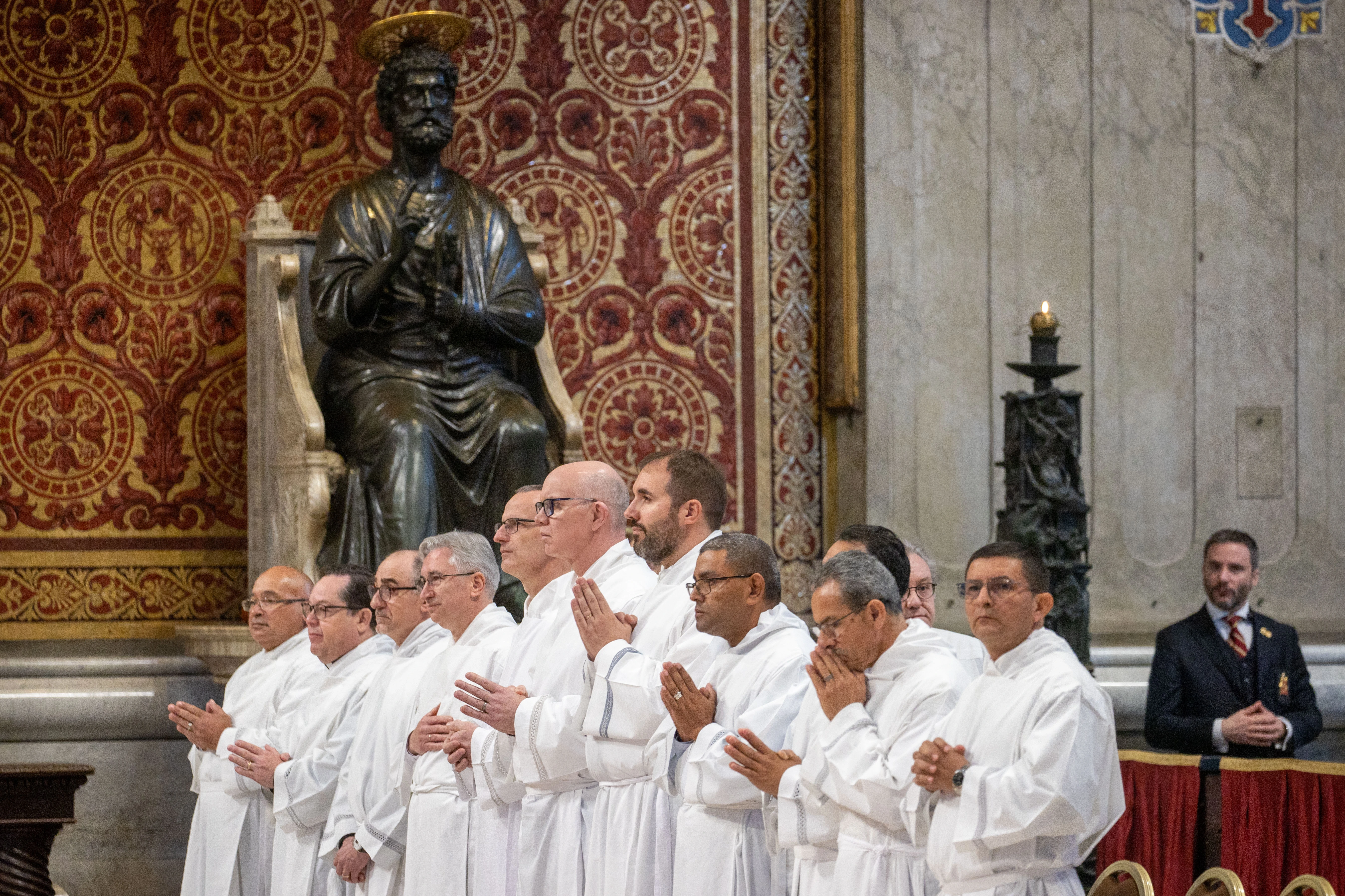 Newly ordained permanent deacons pray during the ordination rite of the Jubilee Mass at St. Peter’s Basilica, beneath a statue of St. Peter, on Feb. 23, 2025. Credit: Daniel Ibáñez/CNA