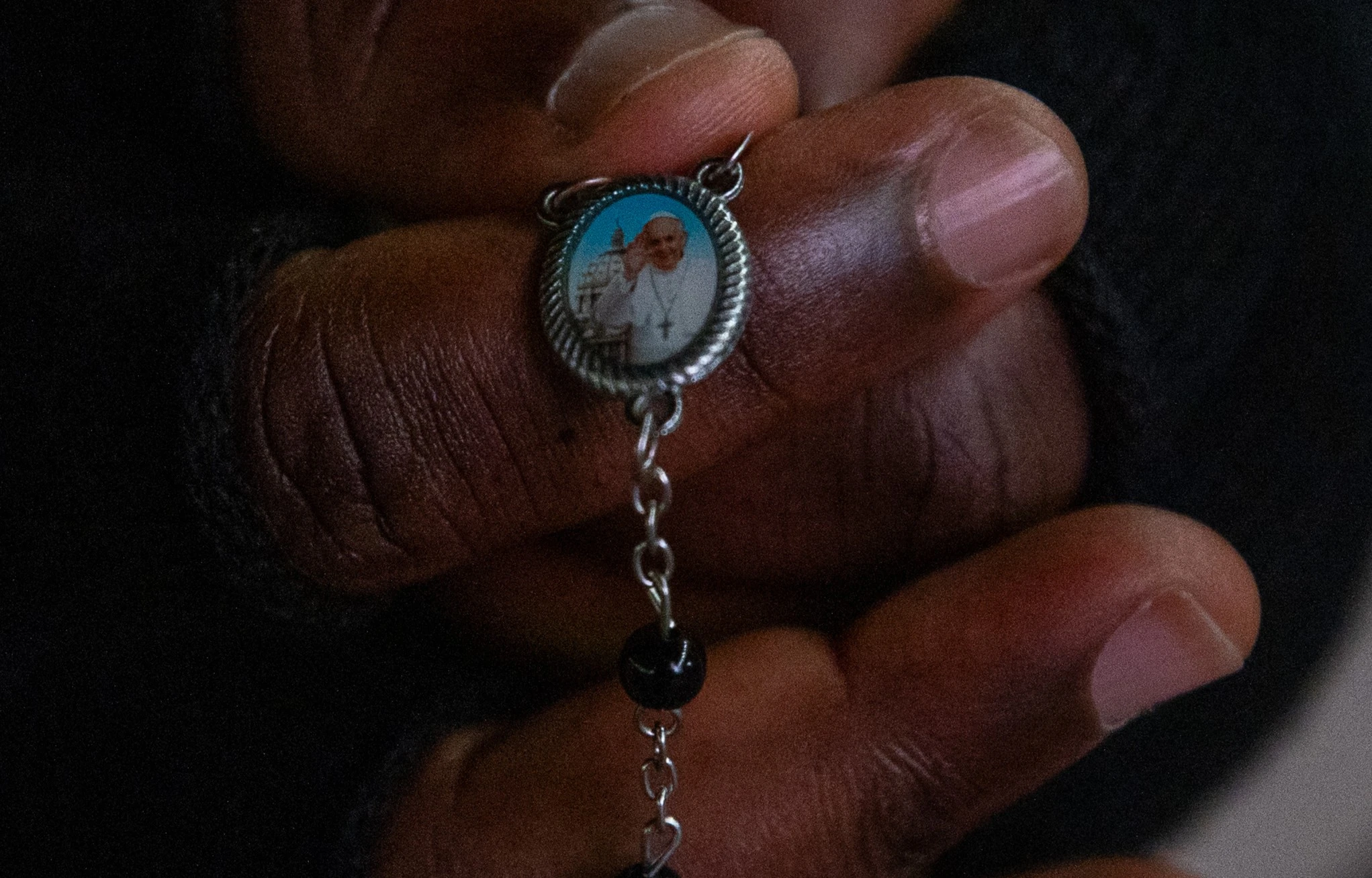A faithful holds a rosary with a medal bearing Pope Francis’ image during the nightly prayer vigil in St. Peter’s Square. Credit: Daniel Ibáñez/CNA