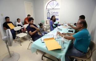 Volunteers at a Catholic Charities Humanitarian Respite Center help Central American refugees prepare to take a bus to go stay with U.S. family on Aug. 17, 2017, in McAllen, Texas. Credit: Vic Hinterlang/Shutterstock
