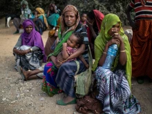 People wait outside a distribution point to receive aid rations in Oromia Region, Ethiopia, in February 2018.