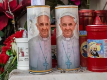 Candles with Pope Francis’ image on them stand outside Gemelli Hospital in Rome on Feb. 21, 2025.