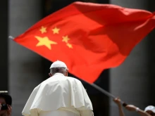 A worshipper waves the flag of China as Pope Francis leaves following the weekly general audience on June 12, 2019, at St. Peter's Square at the Vatican.