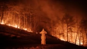 A wildfire blazes next to a stone lantern of family tomb in Andong, South Korea, on March 26, 2025. At least 18 people have been killed in one of South Korea’s worst wildfire outbreaks, with multiple blazes burning and causing “unprecedented damage,” the acting president said.