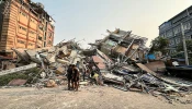People stand past the debris of a collapsed building in Mandalay, Myanmar, on March 28, 2025, after a powerful earthquake killed more than 150 people across Myanmar and Thailand on March 28, toppling buildings and bridges and trapping over 80 workers in an under-construction skyscraper in Bangkok.