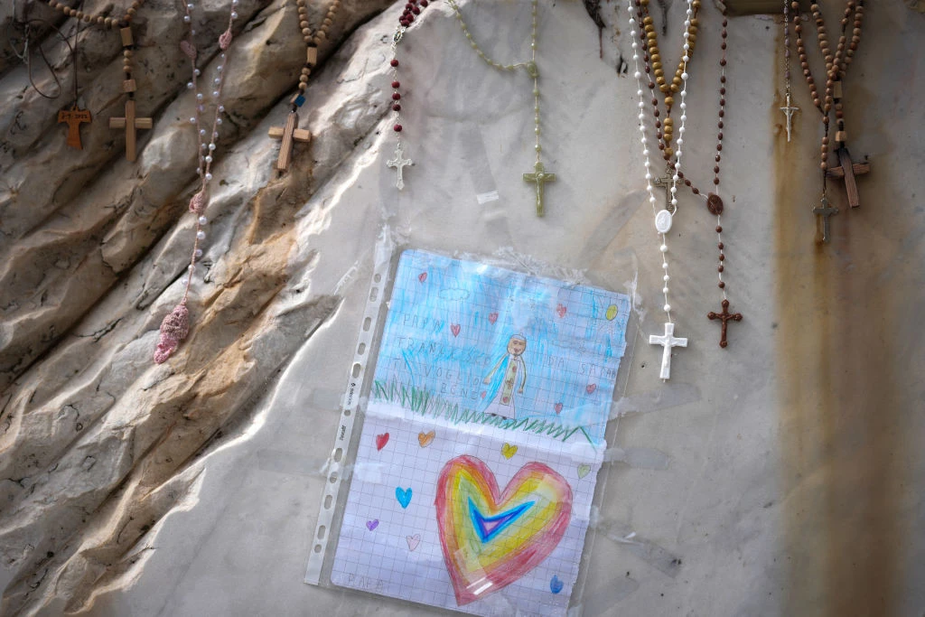 Rosary beads and tributes are placed on the sculpture of St. John Paul II on March 13, 2025, at the main entrance of Gemelli Hospital in Rome, where Pope Francis is being cared for. Today marks the 28th day since Pope Francis was hospitalized in Rome on Feb. 14 and also 12 years since Jorge Mario Bergoglio became Pope Francis.?w=200&h=150