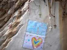 Rosary beads and tributes are placed on the sculpture of St. John Paul II on March 13, 2025, at the main entrance of Gemelli Hospital in Rome, where Pope Francis is being cared for. Today marks the 28th day since Pope Francis was hospitalized in Rome on Feb. 14 and also 12 years since Jorge Mario Bergoglio became Pope Francis.