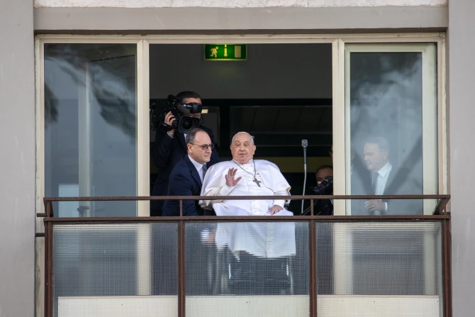 Pope Francis waves from a balcony at Gemelli Hospital in Rome on Sunday, March 23, 2025, following weeks of hospitalization for bilateral pneumonia.