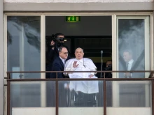 Pope Francis waves from a balcony at Gemelli Hospital in Rome on Sunday, March 23, 2025, following weeks of hospitalization for bilateral pneumonia.