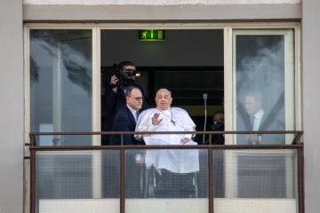 Pope Francis waves from a balcony at Gemelli Hospital in Rome on Sunday, March 23, 2025, following weeks of hospitalization for bilateral pneumonia.