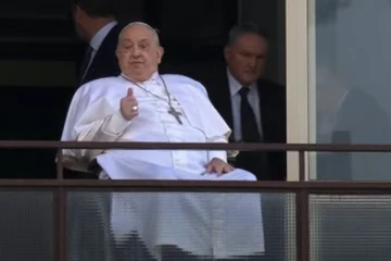 Pope Francis gives a thumbs up gesture from his window at Gemelli Hospital in Rome during his first public appearance in weeks on Sunday, March 23, 2025.