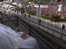 Pope Francis waves to the gathered faithful from the balcony at Gemelli Hospital in Rome on Sunday, March 23, 2025.